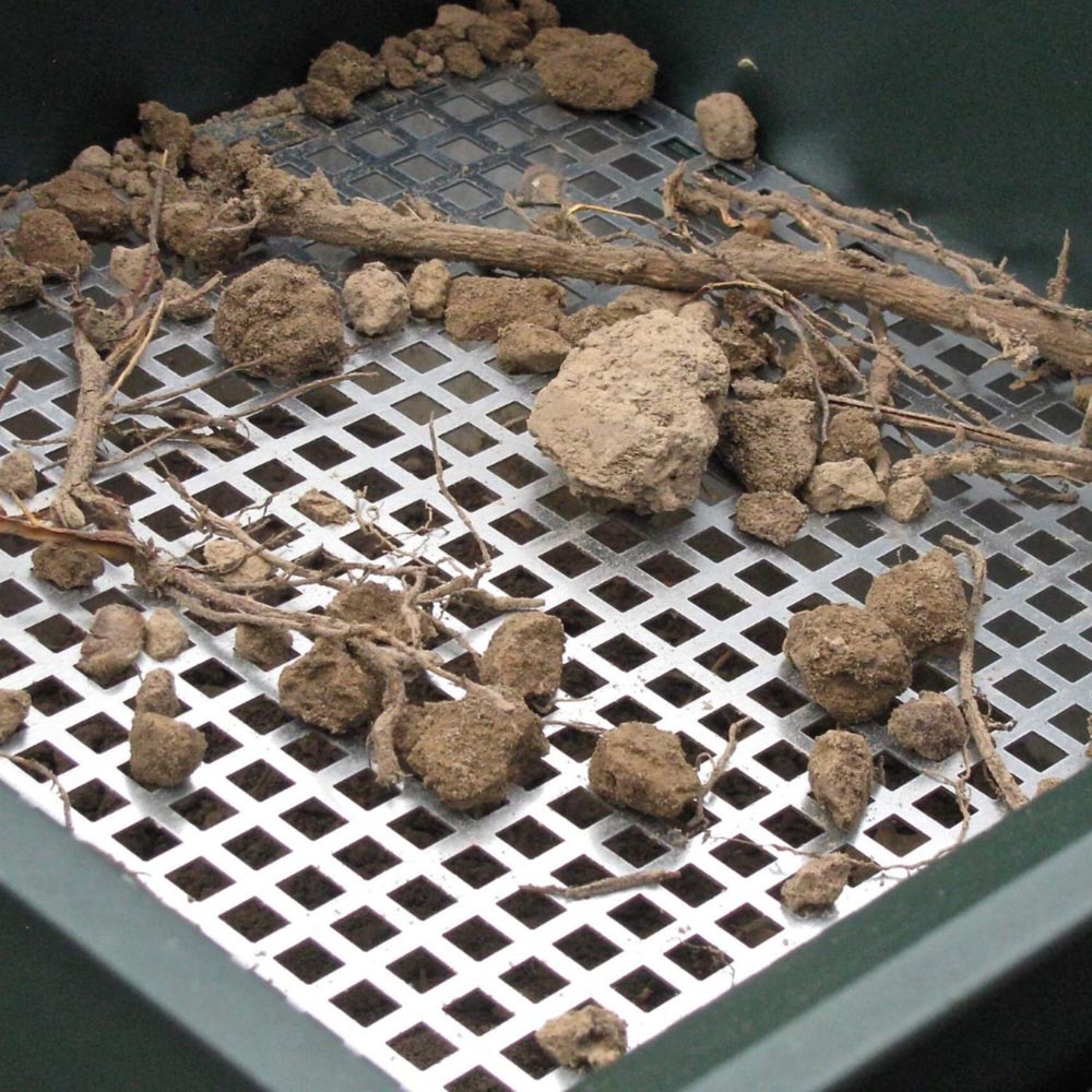 Produkt in Gartenumgebung – Jetroc III bereit für Gartenarbeit, umgeben von Pflanzen und Komposthaufen.